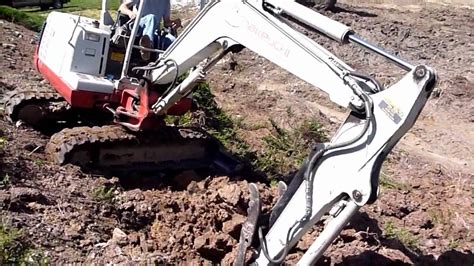 mini excavator trenching on hillside|steep slope mini excavator.